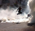 Bahrain, protester leaping through tear gas 